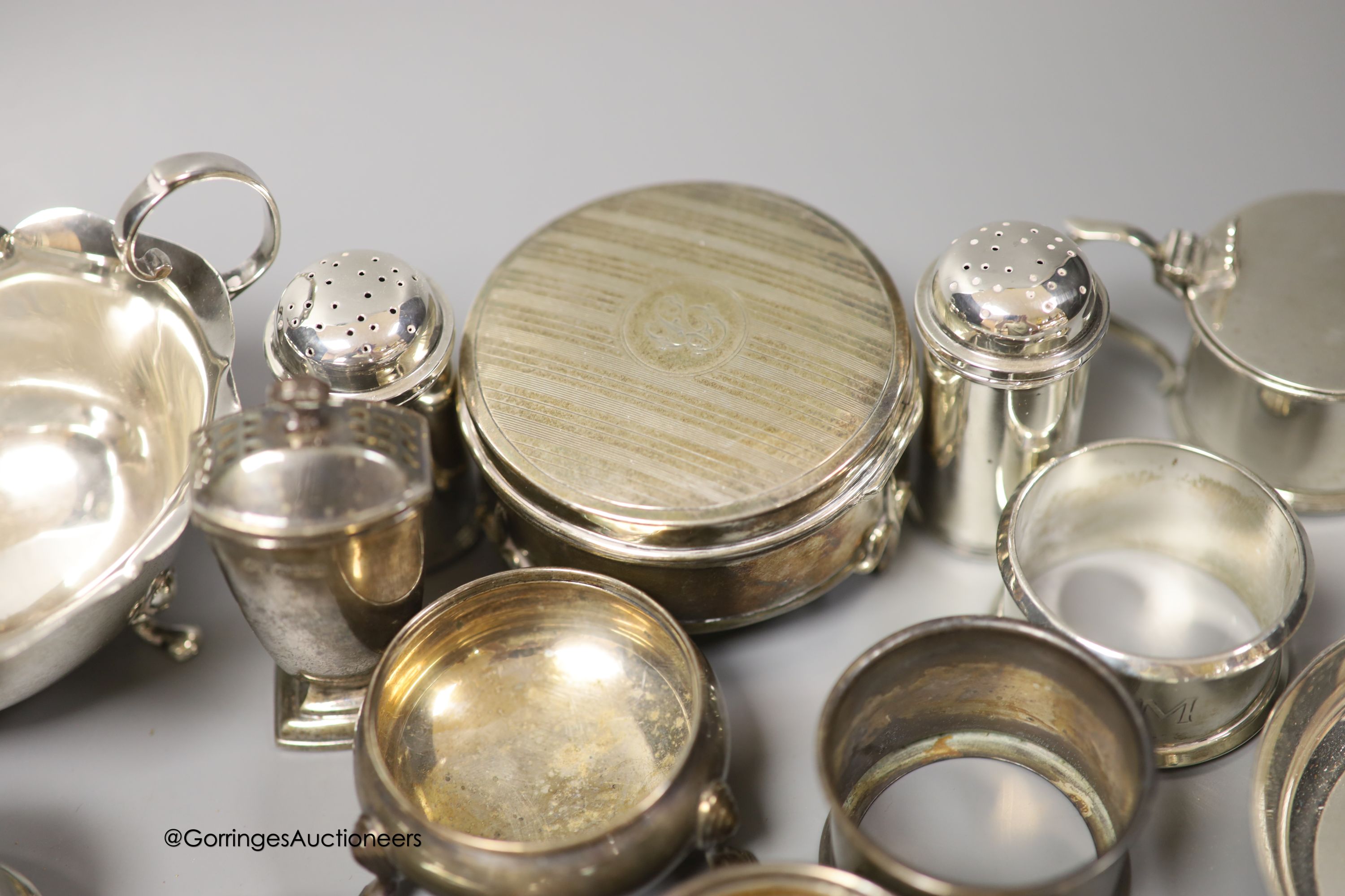 A group of minor silver including a George V trinket box, sauceboat, pair of soup spoons, pair of napkin rings, two bun salts, four small dishes, condiments etc. and three plated items.